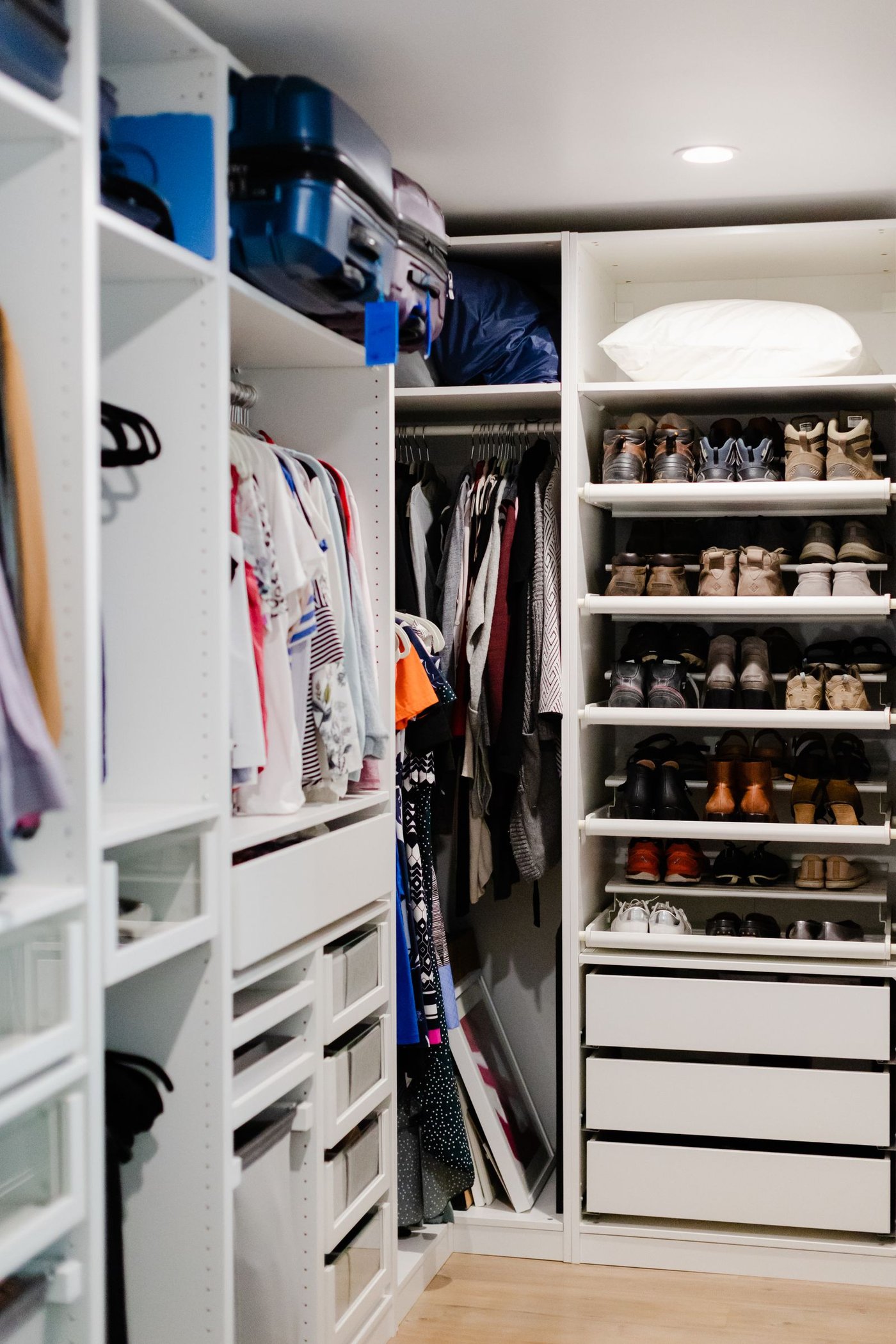 A neat wardrobe with shoes stored on shelves and clothes hanging in organized categories.