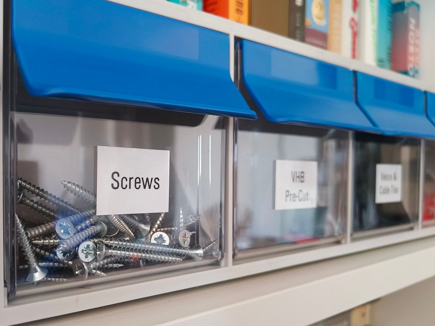 Clearly labeled storage bins on a garage shelf, part of an organized fall storage system.