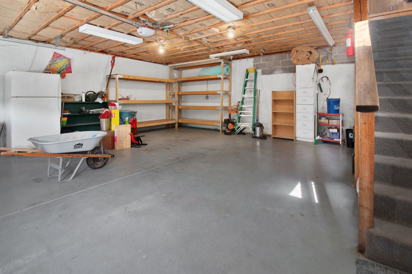 A spacious, tidy garage with wooden shelving, ready for a fall storage reset before winter.