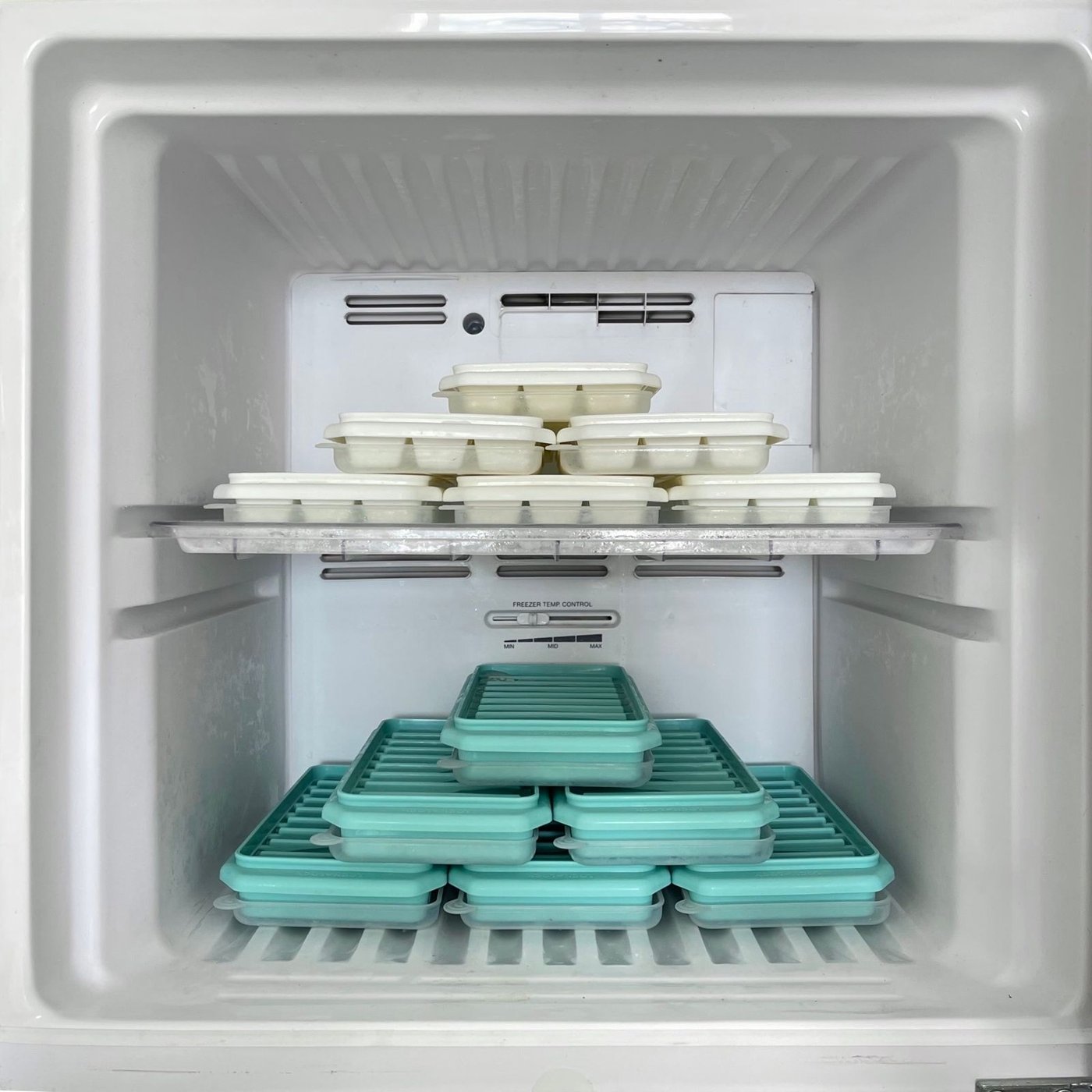 Neatly organized freezer trays and containers, part of a holiday freezer zone system.