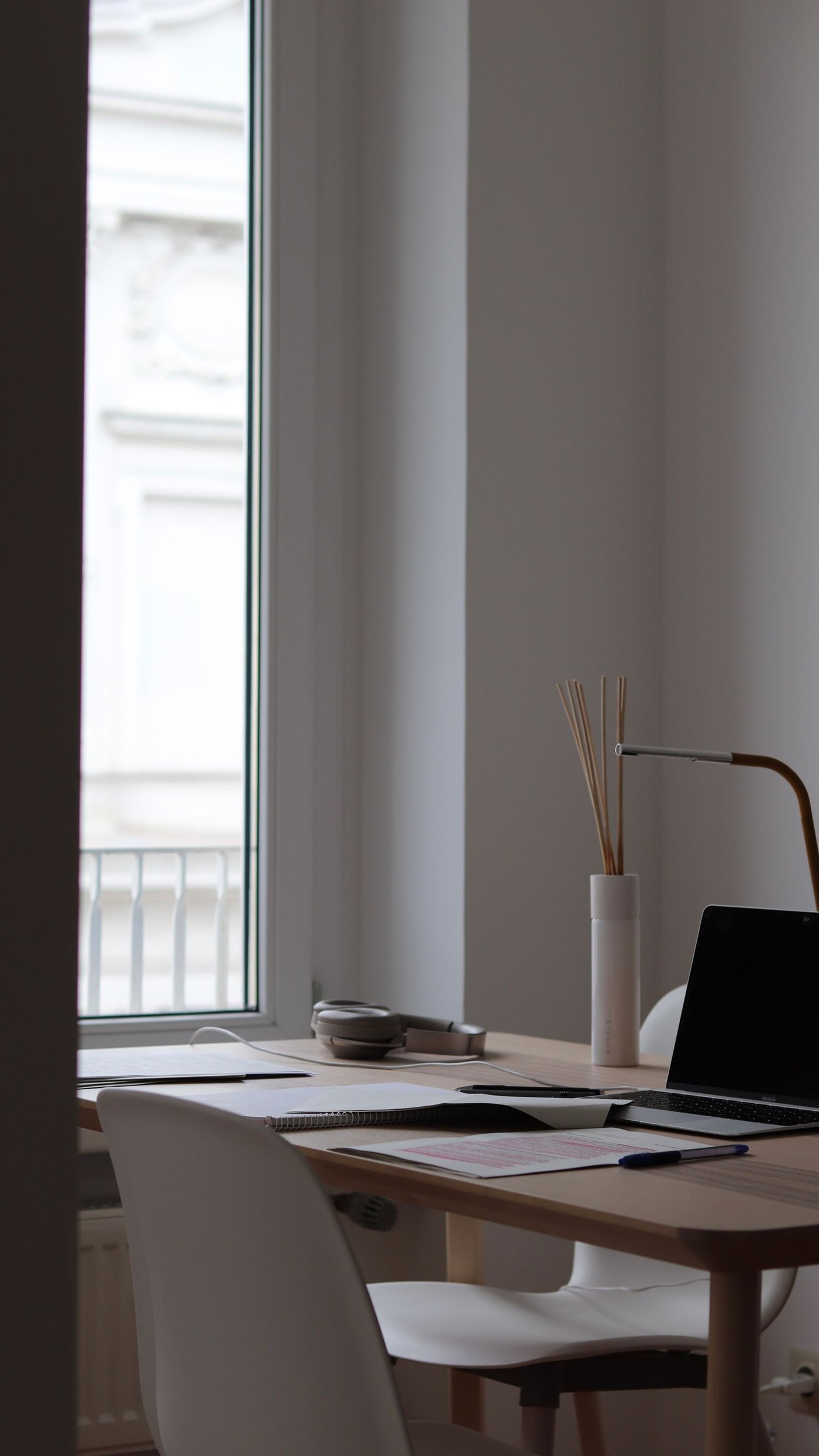 A calm home office desk with a planner and notebook, set up for household management.