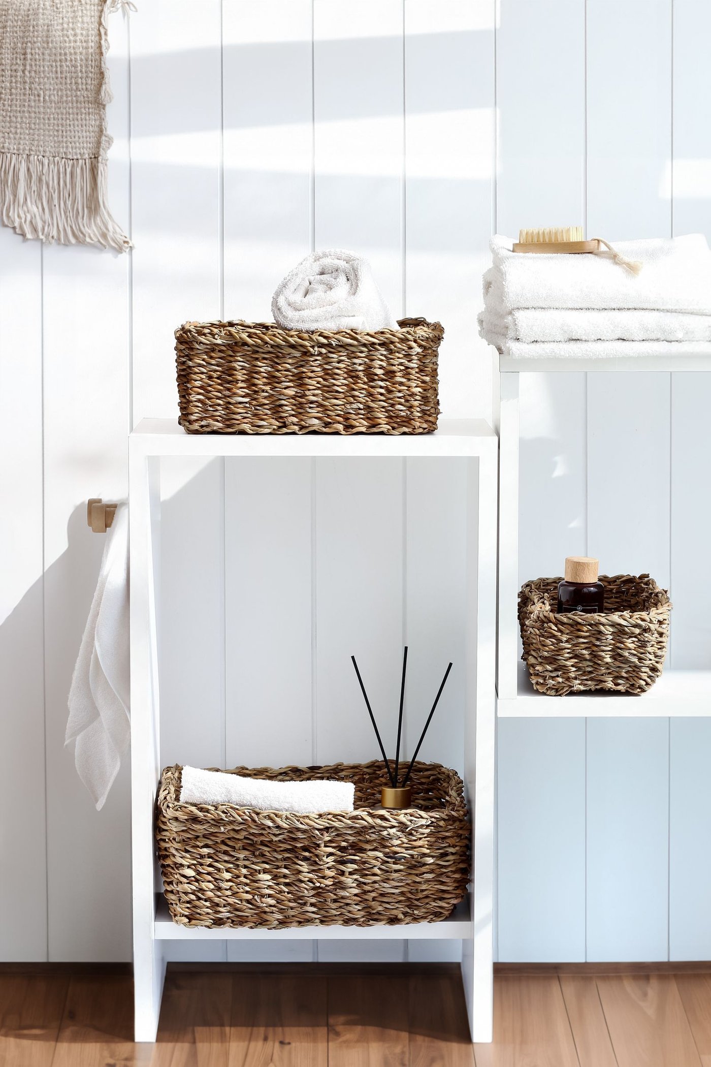 A small, bright bathroom with woven storage baskets making the most of limited space.